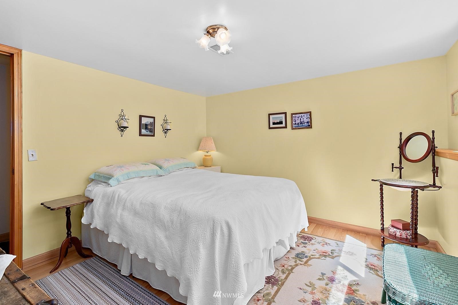 509 Roe Street Steilacoom, WA 98388 - Photo 19 of 40 a bedroom with a bed and wooden floor