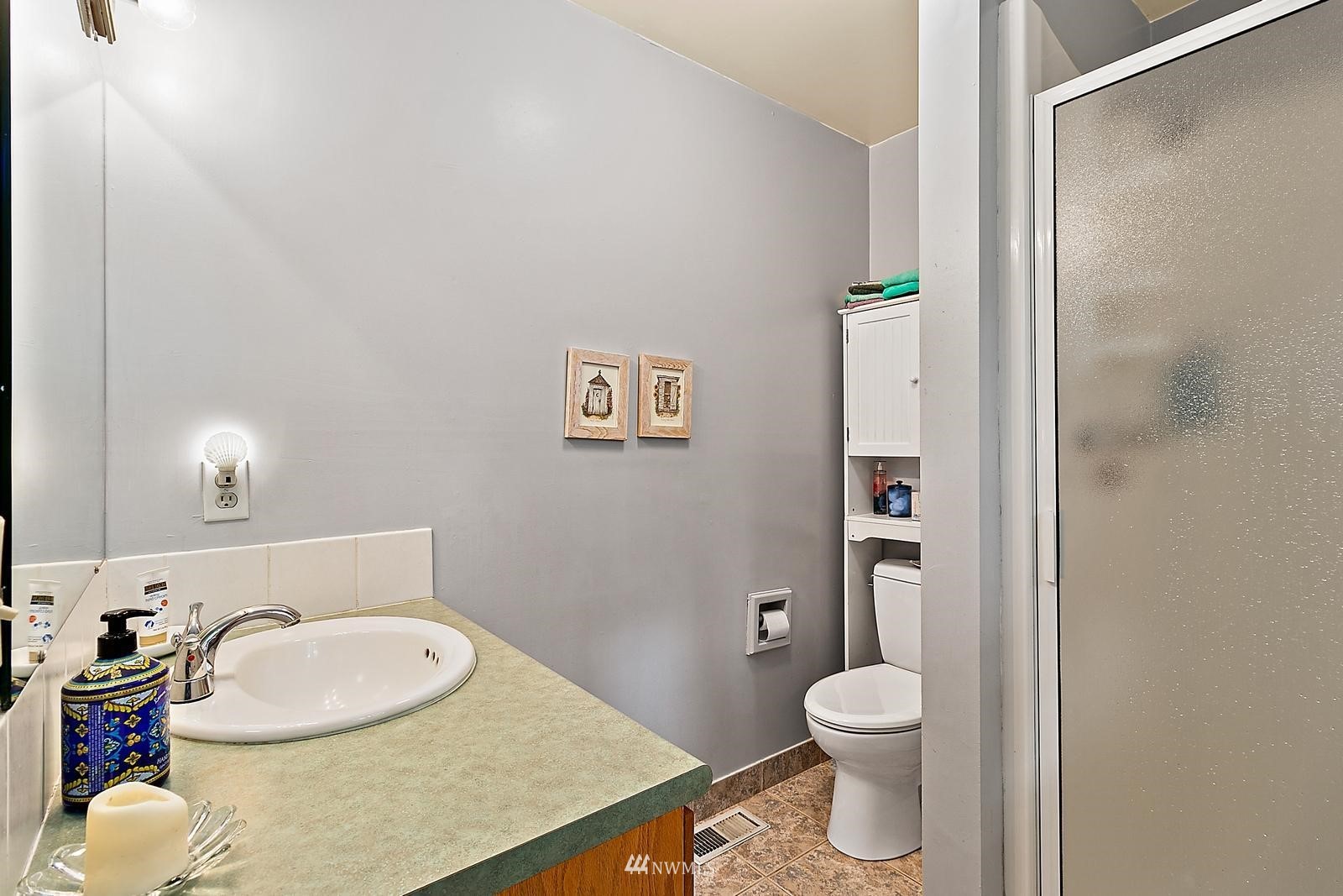 509 Roe Street Steilacoom, WA 98388 - Photo 22 of 40 a bathroom with a granite countertop toilet and a sink