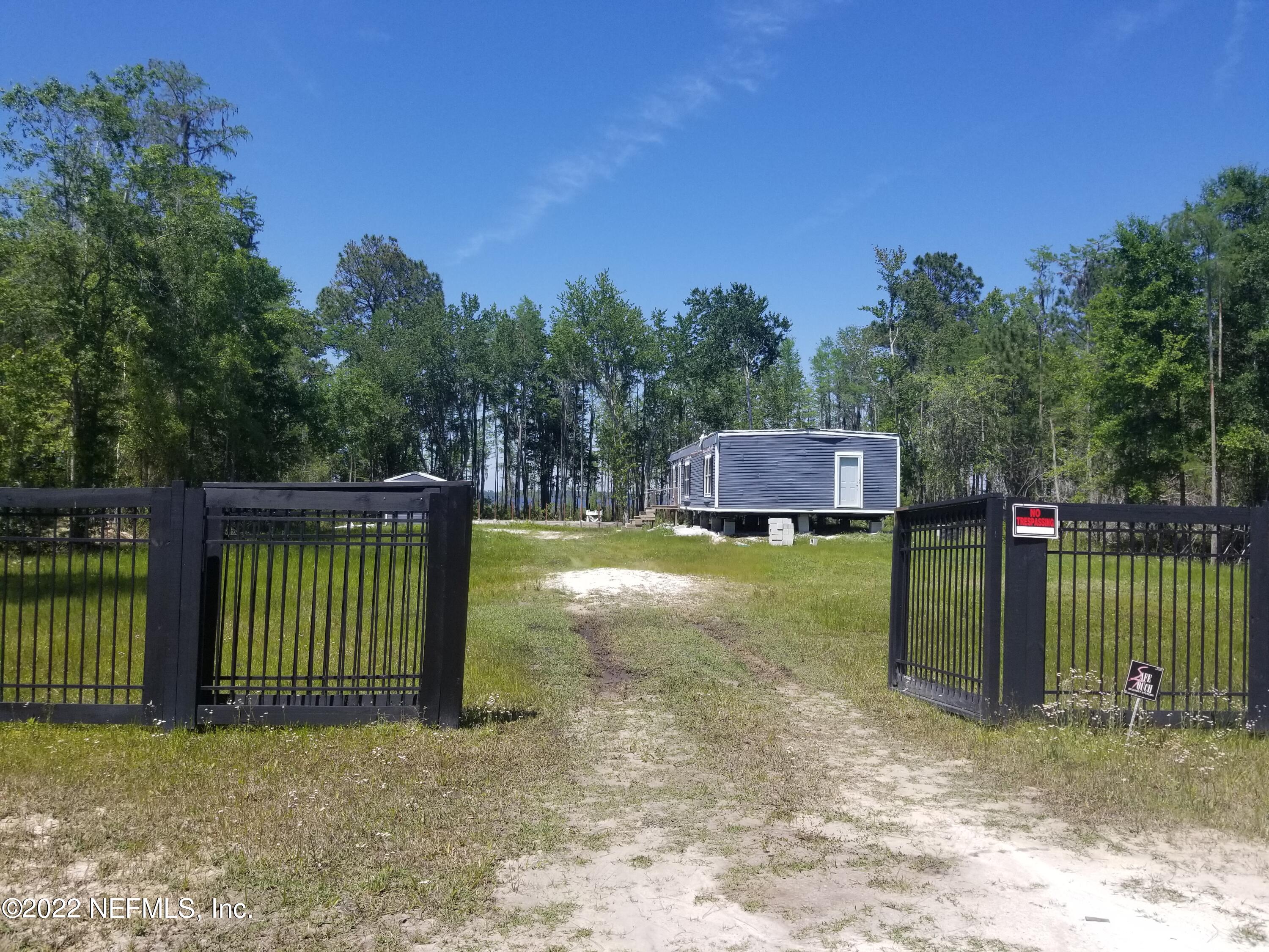 a view of a house with backyard and a fence