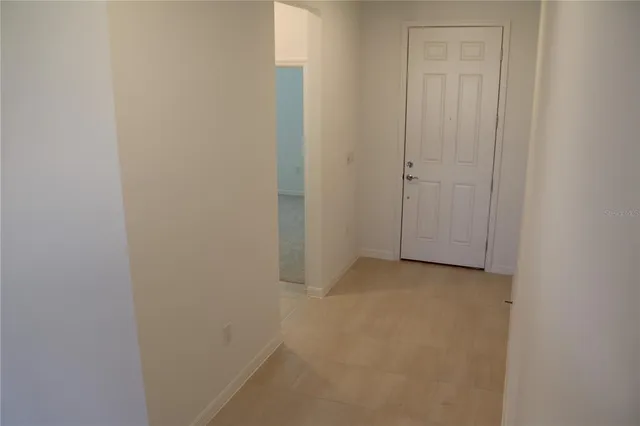 a living room with stainless steel appliances furniture a refrigerator and a kitchen