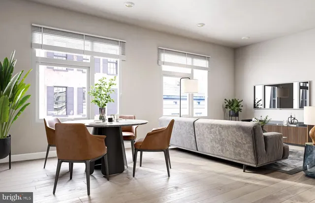 a living room with furniture a potted plant and a large window