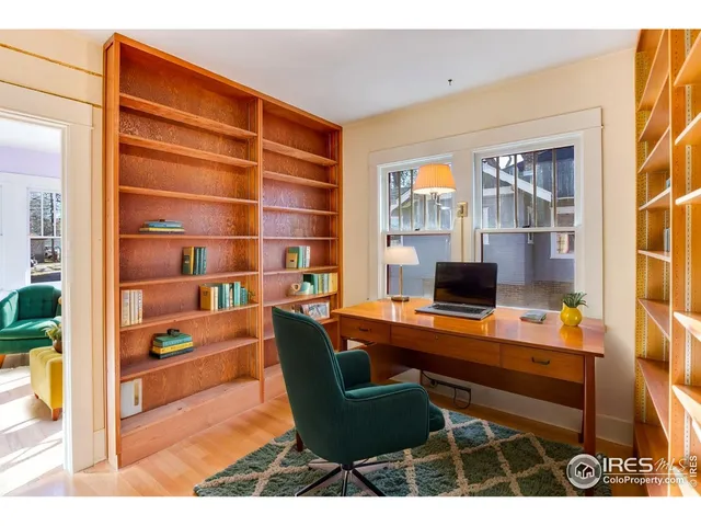 a view of a workspace with furniture and a window