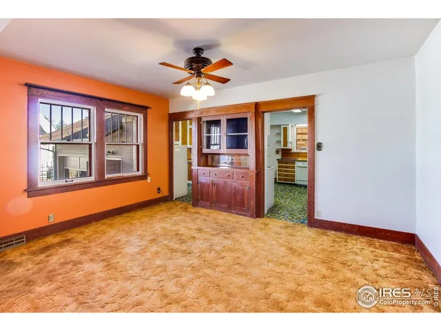 a view of an empty room with window and cabinet