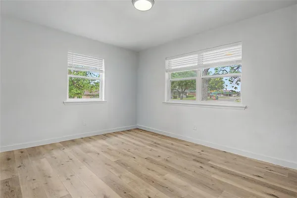 a view of a hallway with furniture and a livingroom with wooden floor