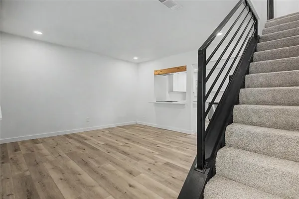 a view of a hallway with wooden floor and staircase