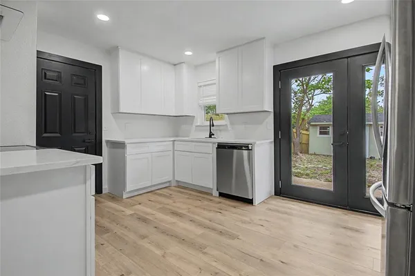 a kitchen with a refrigerator stove and white cabinets