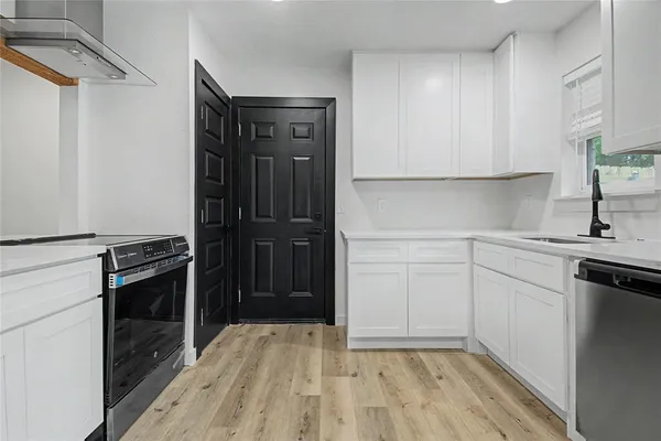 a kitchen with a sink cabinets and wooden floor