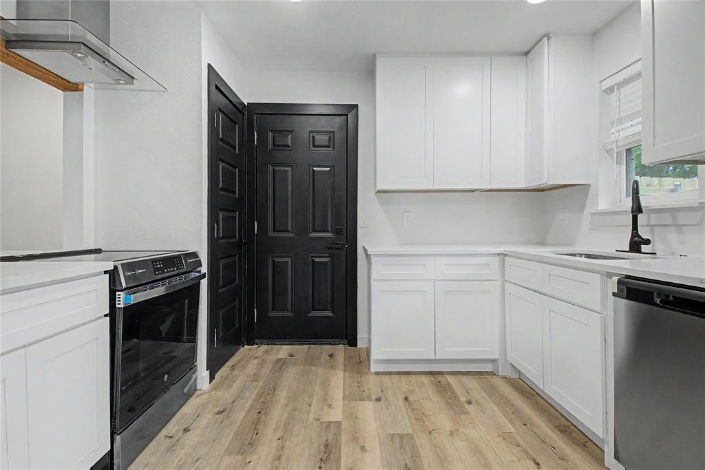 502 Rogers Way Rockwall, TX 75087 - Photo 6 of 23 a kitchen with a refrigerator stove and white cabinets