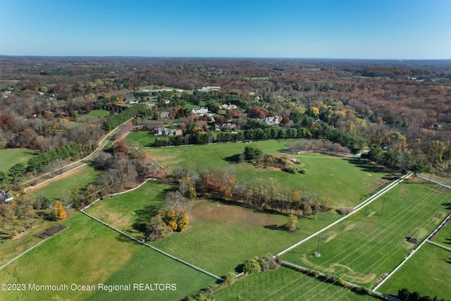 an aerial view of residential houses with outdoor space and trees