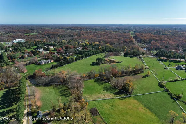 an aerial view of green landscape with trees houses and lake view