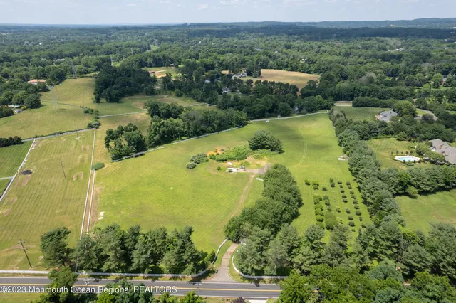 an aerial view of residential houses with outdoor space and trees