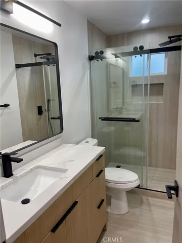 a bathroom with a sink a toilet and shower
