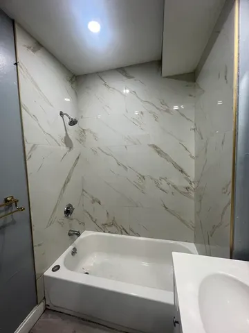 a bathroom with a bathtub and shower