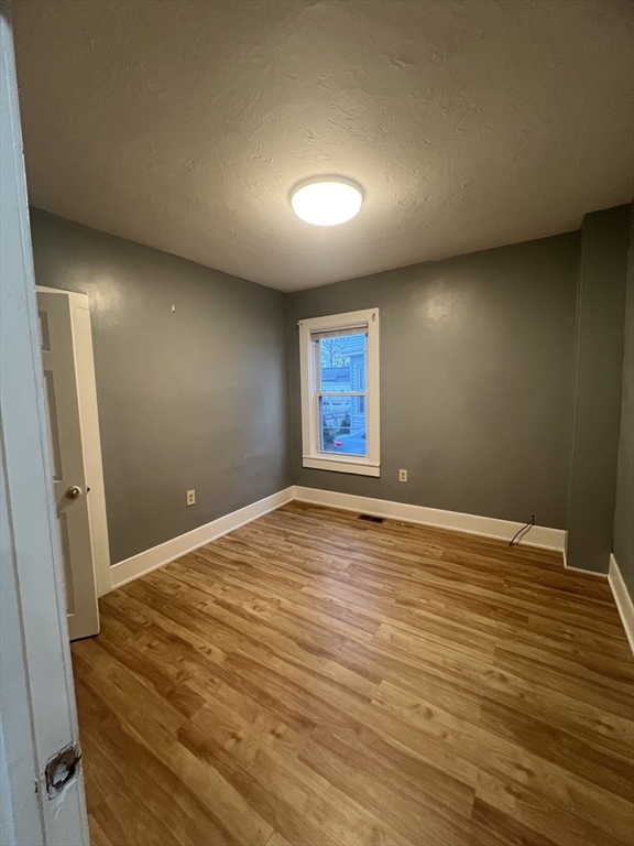 10 Essex Street, Unit 1 Brockton, MA 02301 - Photo 9 of 10 an empty room with wooden floor and windows