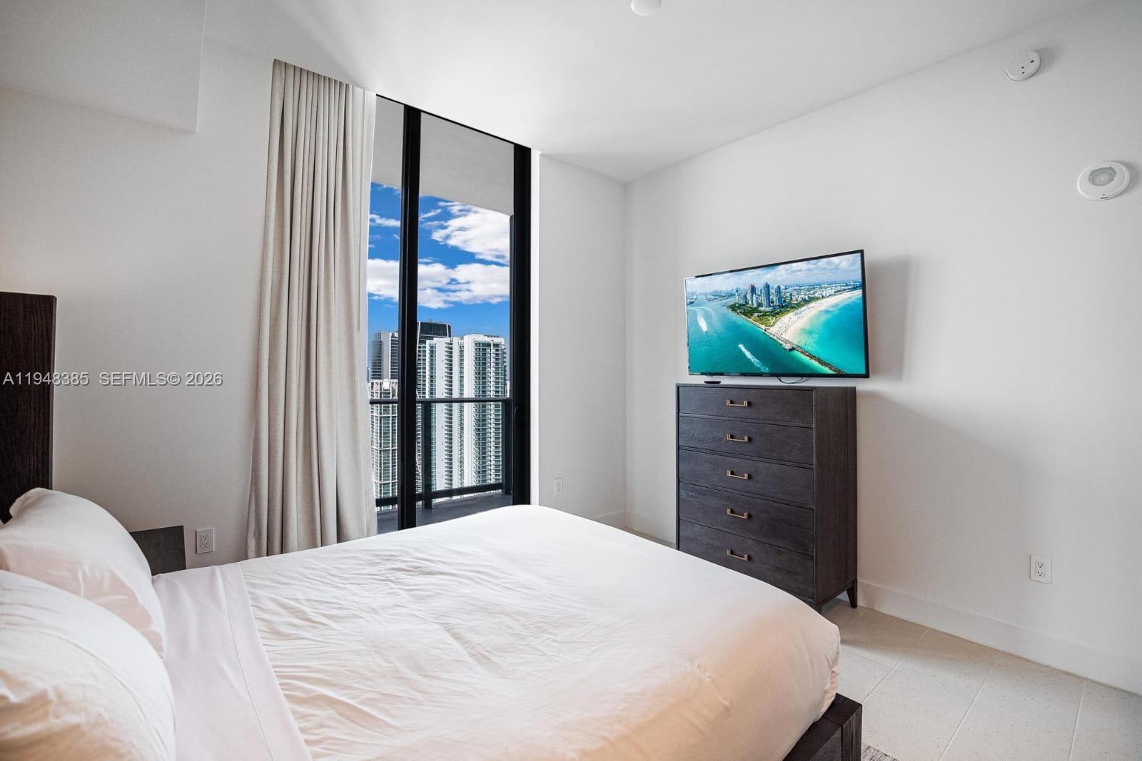 159 Northeast 6th Street, Unit 5101 Miami, FL 33132 - Photo 10 of 47 a bedroom with a bed and a dresser