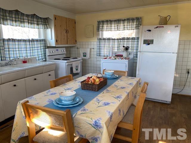 871 Halifax Road Roxboro, NC 27573 - Photo 29 of 45 a kitchen with sink refrigerator dining table and chairs
