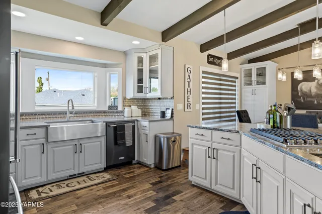 a kitchen with white cabinets and appliances