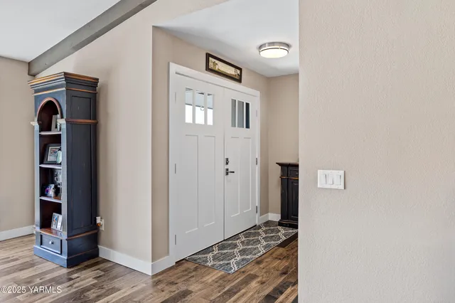 a view of a hallway with wooden floor and closet