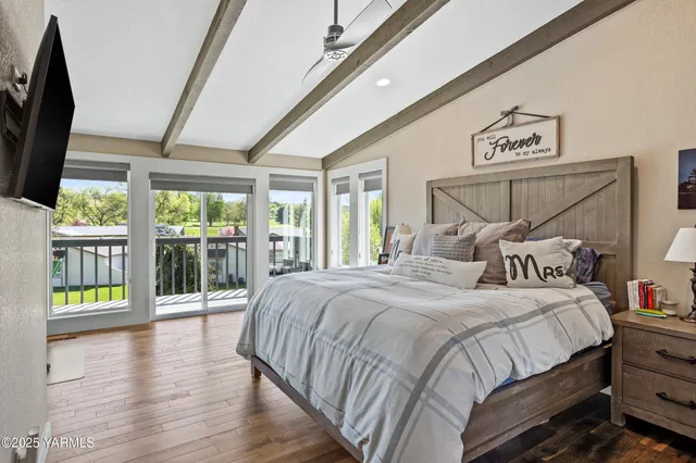 a bedroom with a balcony a bed and a large window