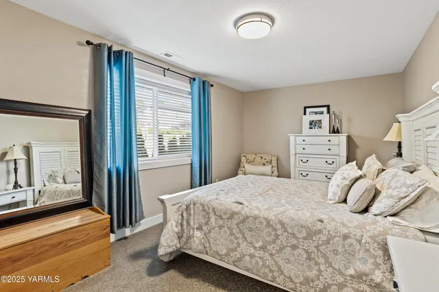 a bedroom with a bed and a large mirror