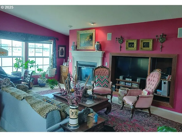 a living room with furniture a fireplace and floor to ceiling windows
