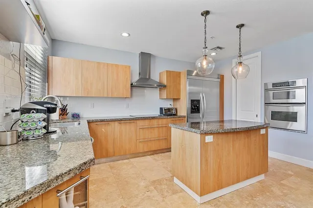 a kitchen with stainless steel appliances granite countertop a sink a stove top oven a counter space and cabinets