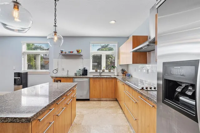 a kitchen with stainless steel appliances granite countertop a sink and stove top oven