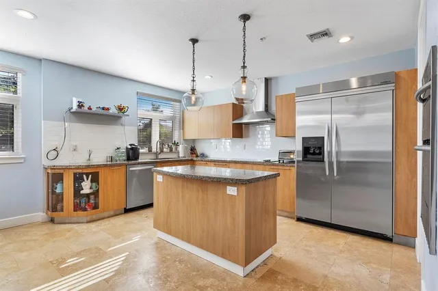 a kitchen with stainless steel appliances granite countertop a refrigerator a sink and a stove