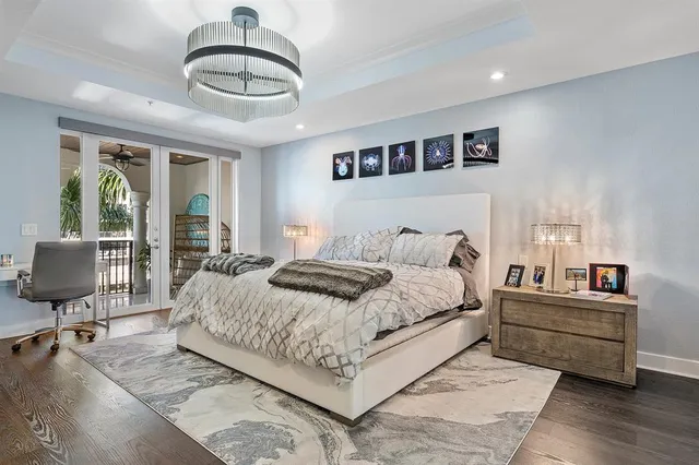 a bedroom with a large bed and wooden floor