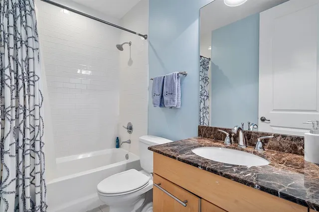 a bathroom with a granite countertop sink toilet and shower