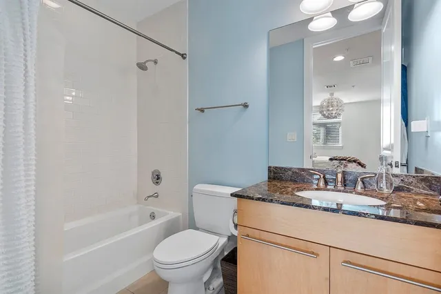 a bathroom with a granite countertop sink toilet and shower