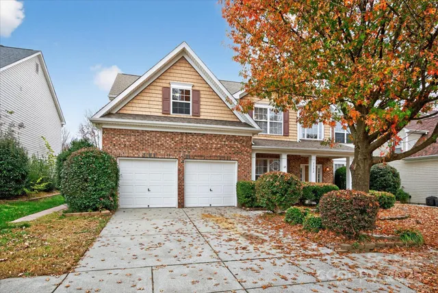 a view of staircase with lots of frames on wall and wooden floor