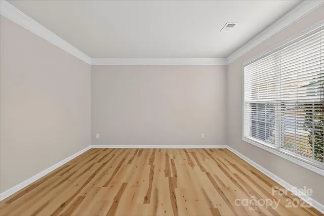 a view of a hallway with wooden floor and windows