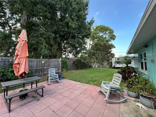 a view of a house with backyard sitting area and garden