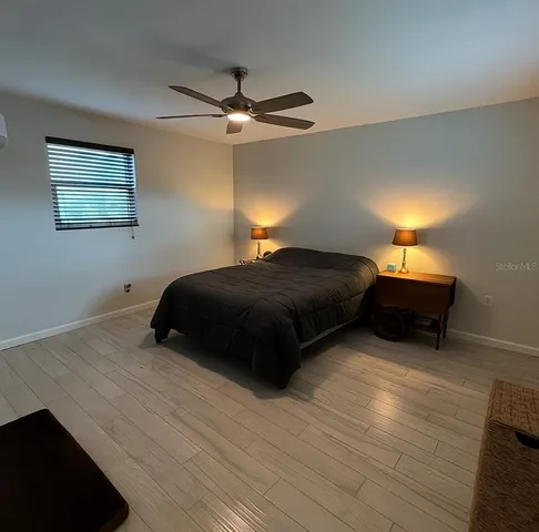a bedroom with a bed and a ceiling fan