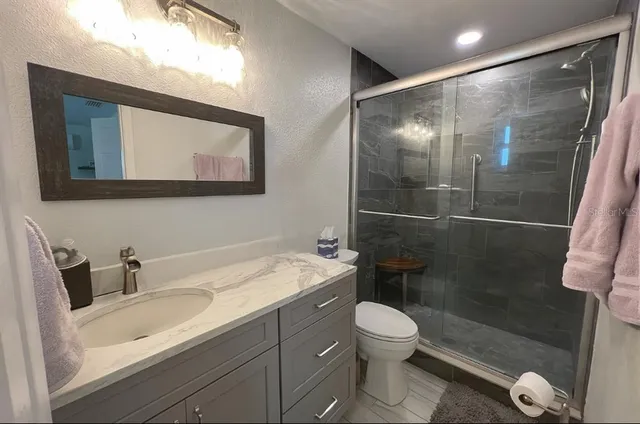 a bathroom with a sink a toilet and a shower
