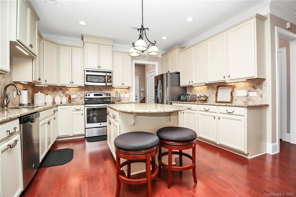 911 Ospre Lane Fort Mill, SC 29708 - Photo 12 of 45 a kitchen with stainless steel appliances granite countertop a stove a sink dishwasher a stove a refrigerator with a dining table and chairs