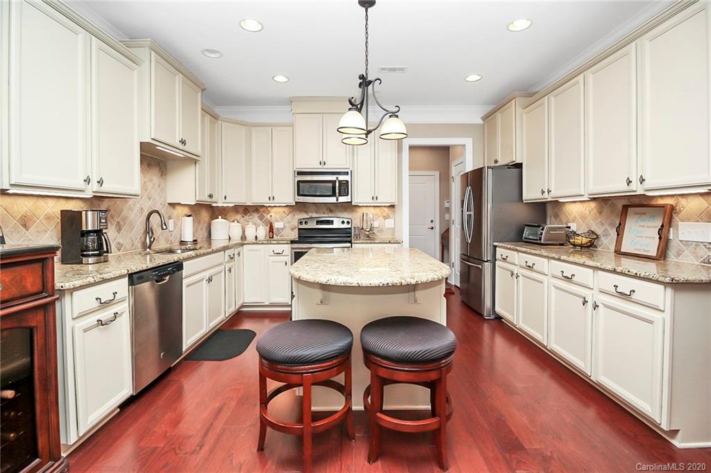 911 Ospre Lane Fort Mill, SC 29708 - Photo 13 of 45 a kitchen with stainless steel appliances granite countertop a stove a sink dishwasher a refrigerator a stove a kitchen island with a dining table and chairs