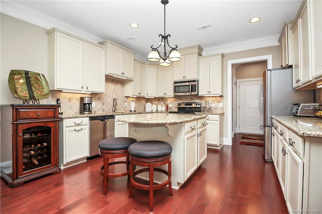911 Ospre Lane Fort Mill, SC 29708 - Photo 14 of 45 a kitchen with kitchen island granite countertop wooden floors granite counter and stainless steel appliances