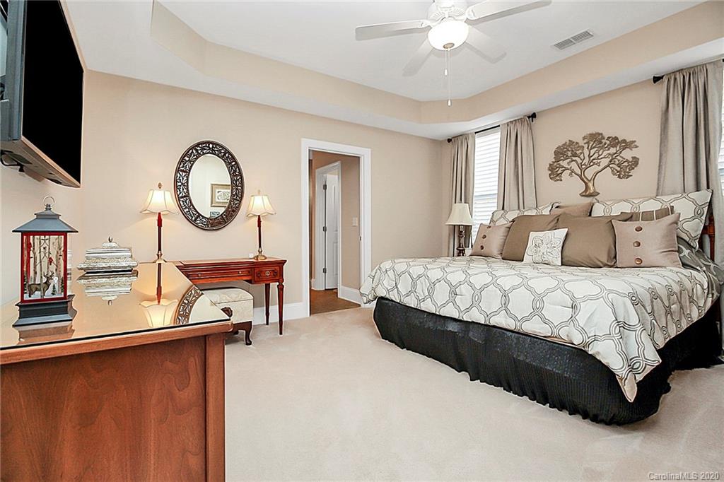 911 Ospre Lane Fort Mill, SC 29708 - Photo 18 of 45 a bedroom with a bed a mirror on the dresser and a large window