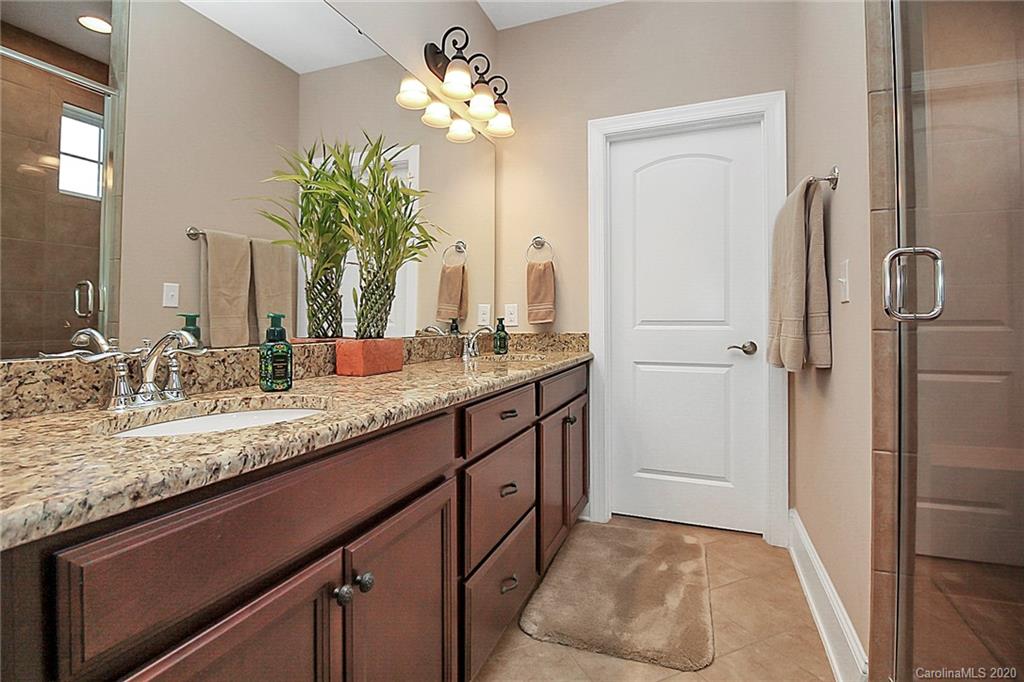 911 Ospre Lane Fort Mill, SC 29708 - Photo 21 of 45 a bathroom with a granite countertop sink a large mirror and a shower