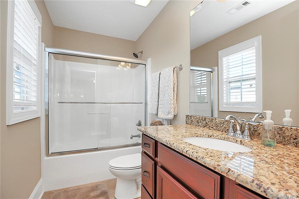 911 Ospre Lane Fort Mill, SC 29708 - Photo 34 of 45 a bathroom with a granite countertop sink toilet and shower