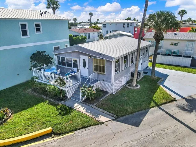 a aerial view of a house with a yard table and chairs