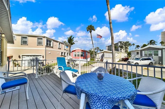 a view of a balcony with dining table and chairs