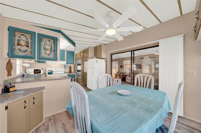 a view of a dining room with furniture a chandelier and large window