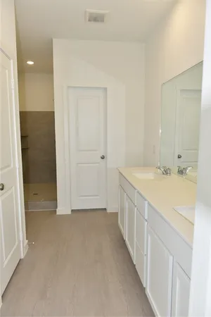 a spacious bathroom with a double vanity sink and a mirror
