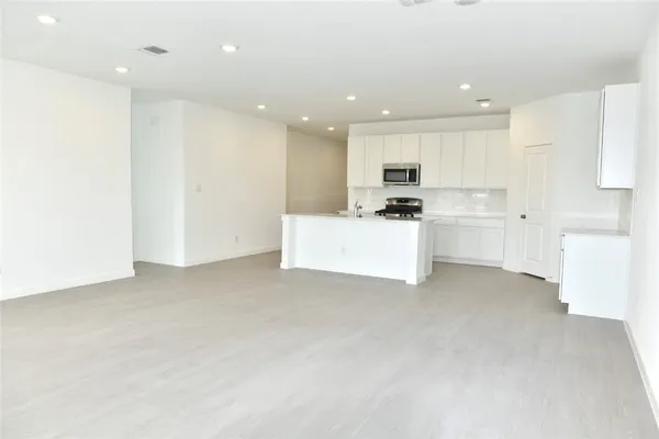 a view of kitchen with kitchen island a sink stainless steel appliances and cabinets