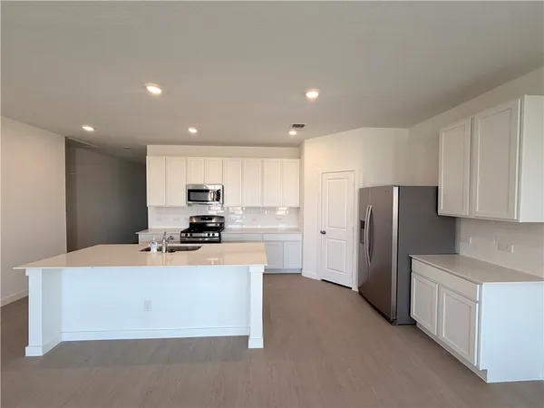 a kitchen with stainless steel appliances a refrigerator and a stove