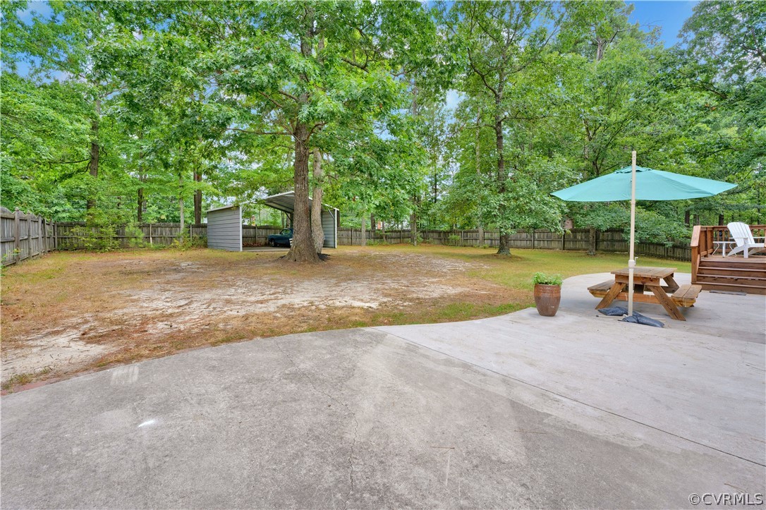 7531 Genuine Risk Lane Midlothian, VA 23112 - Photo 44 of 50 a view of a patio with a table and chairs under an umbrella