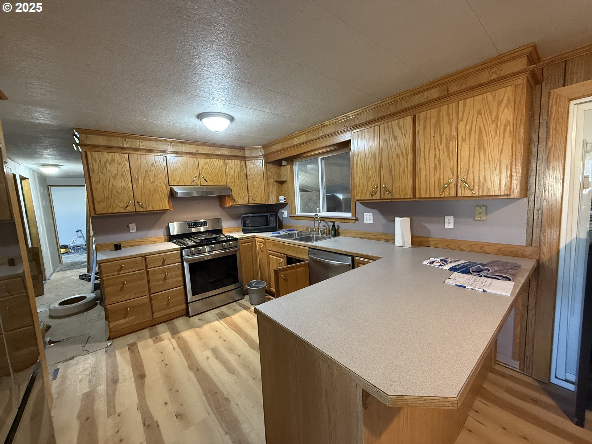 260 North 13th Street Elgin, OR 97827 - Photo 3 of 13 a kitchen with a refrigerator a stove top oven a sink dishwasher and wooden cabinets with wooden floor